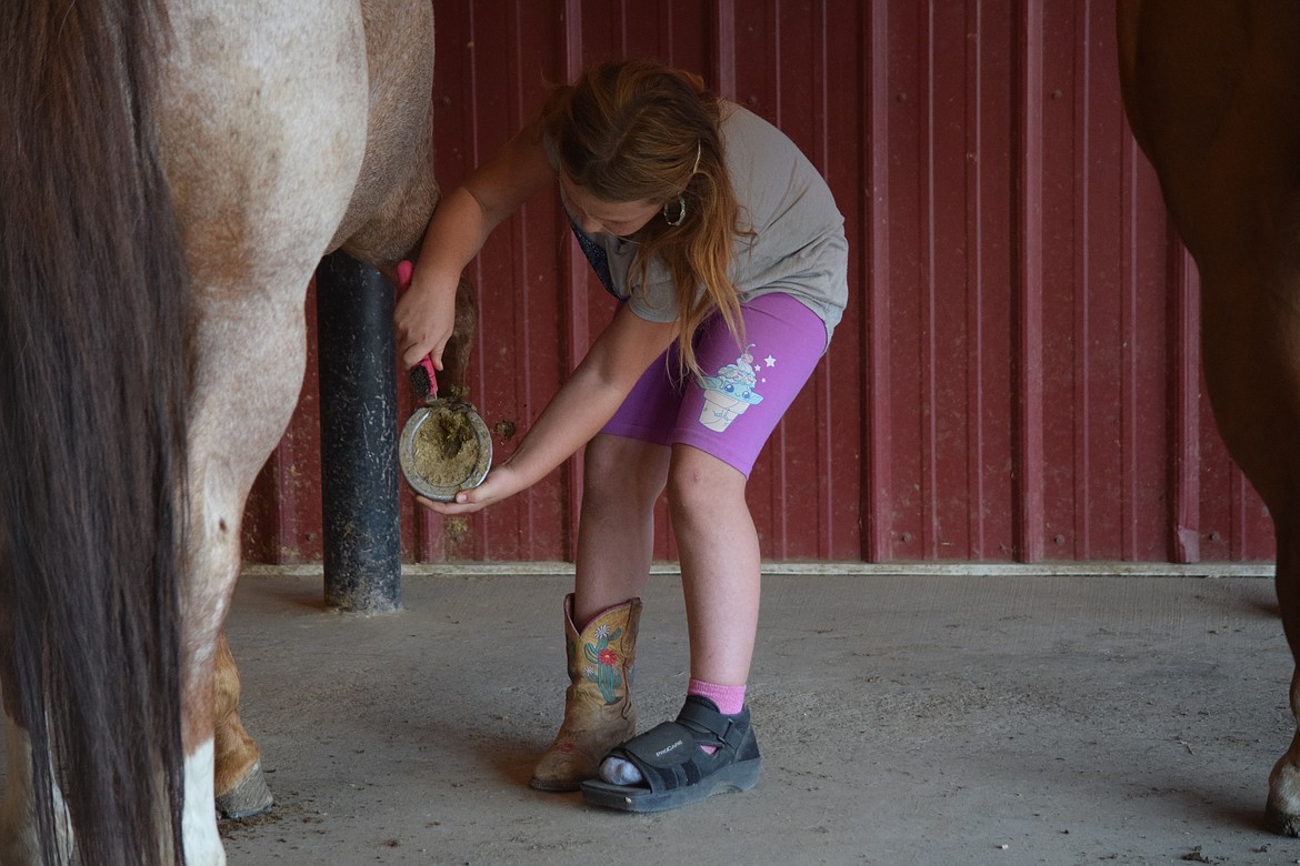 Maggie Winona, 8, helps get a horse ready for Miss Rodeo Washington Lexy Hibbs to ride as part of Pink 50 Horse Challenge at the Iron Legacy Ranch south of Ritzville on Sunday.