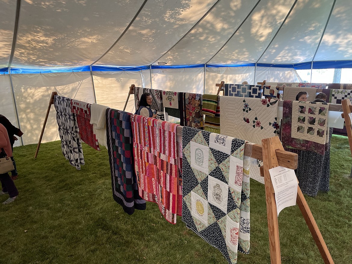 Quilts on display for auction in the auction tent at the Mennonite Country Auction near Ritzville on Saturday.