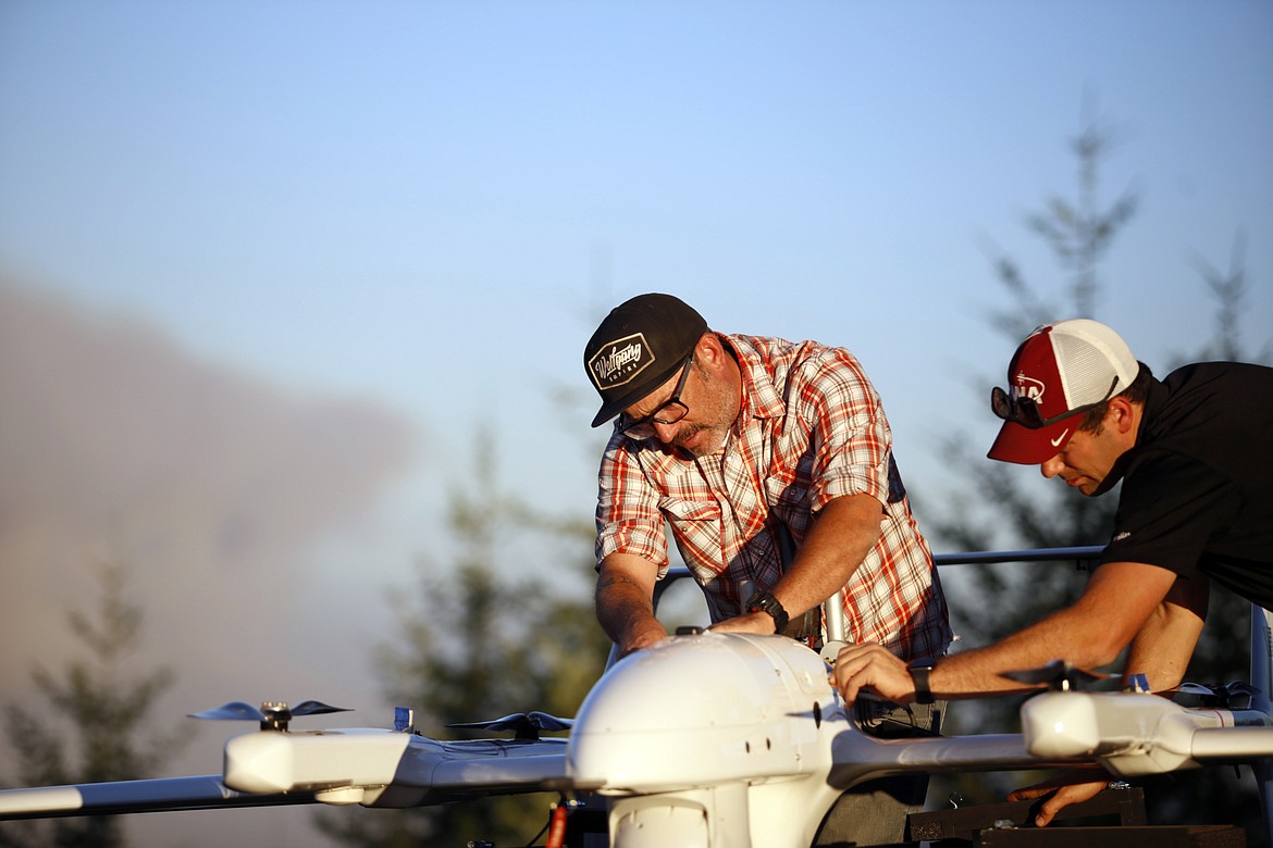 Leonard Pies and Jordan Hahn with Precision Integrated Programs / Overwatch Aero perform pre-flight maintenance on the FVR-90 fixed wing drone, before takeoff to fly around the perimeter of the Lightning Complex Fire near Willow Creek, Calif., on Aug. 31.