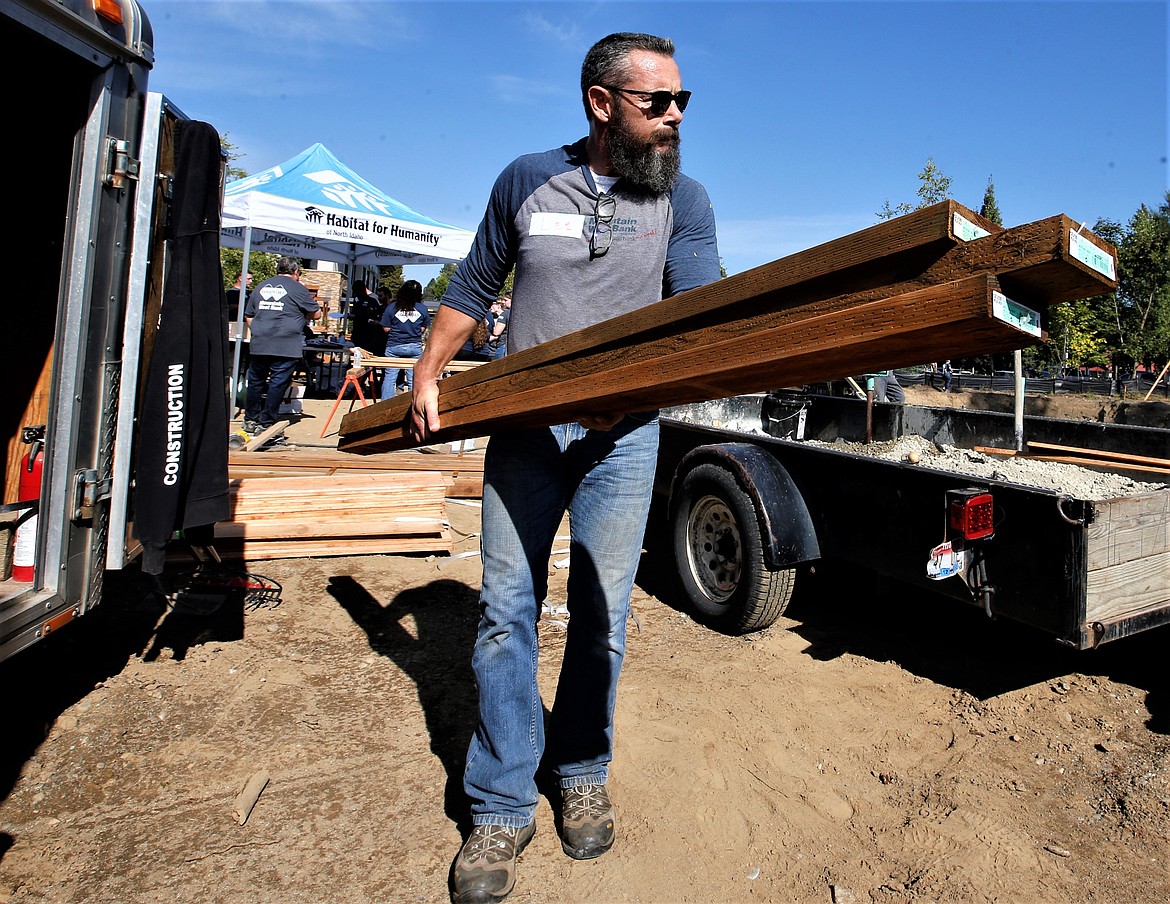 Lee Bainard with Mountain West Bank pitches in at the Habitat for Humanity worksite south of Neider Avenue near Fourth Street on Wednesday morning.