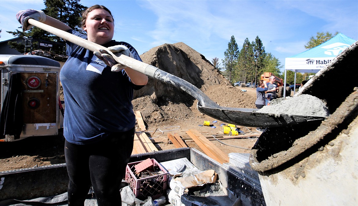 Krystal Vigoa with Mountain West Bank shovels material into a concrete mixer at the Habitat for Humanity worksite on Wednesday.