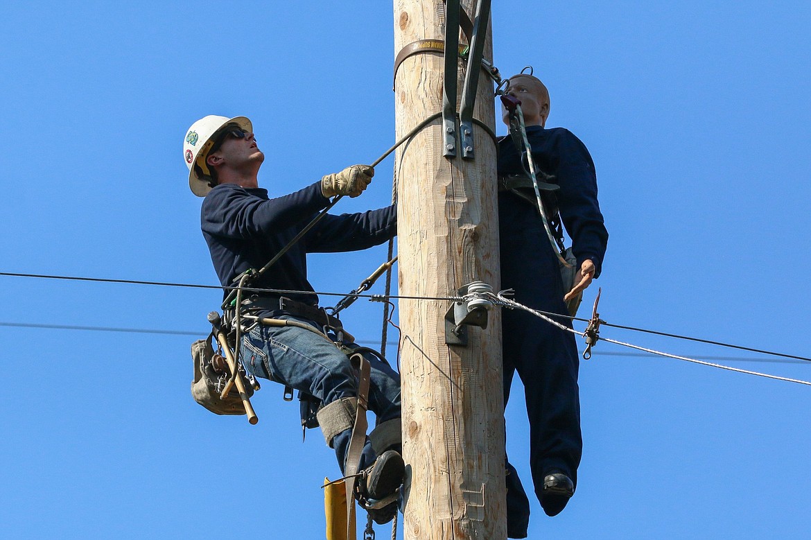 Grant PUD journeyman lineman Carson Fisk, at the top of a power pole, navigated getting the dummy down safely at the Washington State Pole Top Rescue Competition.