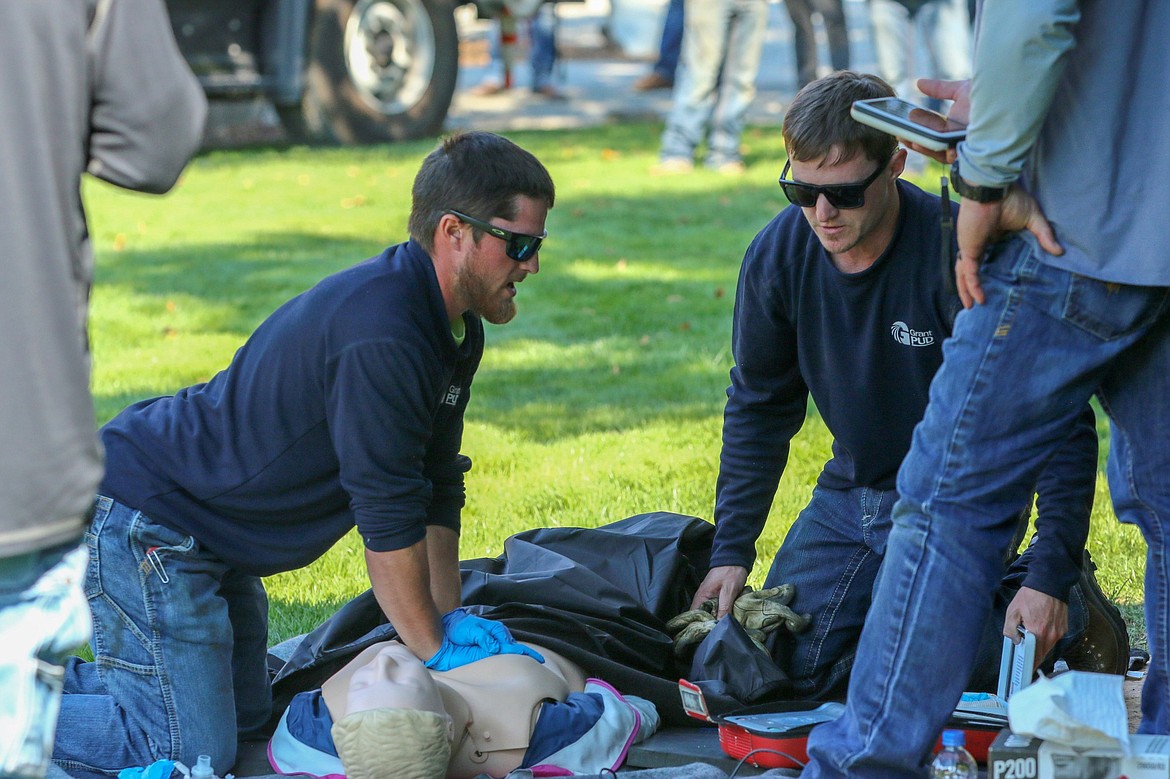 Grant PUD linemen Sheldon Kosa, left, and Carson Fisk, right, do CPR on a mannequin, one of the tasks assigned in the competition.