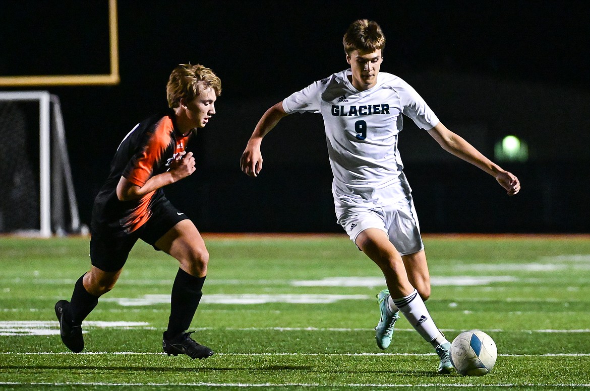 Glacier's Bridger Dalla Betta (9) pushes the ball upfield against Flathead's Stephen Gislason (17) at Legends Stadium on Thursday, Oct. 6. (Casey Kreider/Daily Inter Lake)