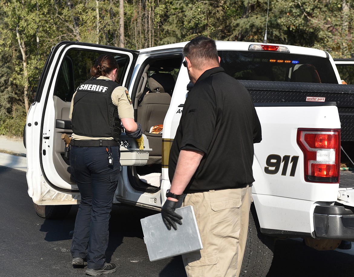 Authorities load several crates of cats during the initial effort to gather the animals last month on East Edgewood Drive. (Julie Engler/Whitefish Pilot)