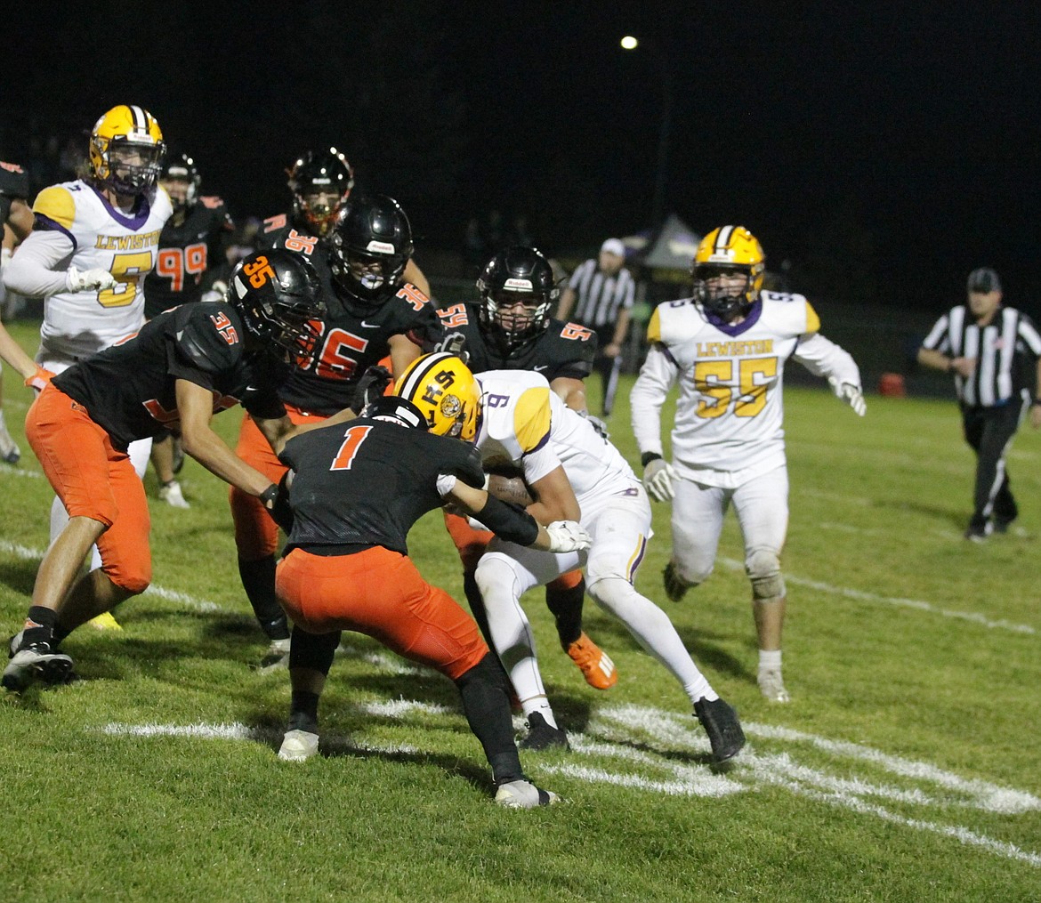 JASON ELLIOTT/Press
Post Falls defenders Dylan Wolfe (1), Tyras Blake (35), Max Lickfold (36) and Gentry Smith (54) bring down Lewiston quarterback Drew Hottinger during the third quarter of Friday's game at Trojan Stadium.