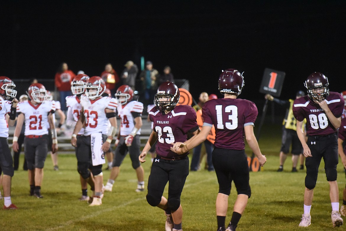 Troy freshman Emerson Downey (23) is congratulated by teammate Rowyn Shupe (13) after intercepting a pass against Arlee on Friday, Oct. 7. (Scott Shindledecker/The Western News)