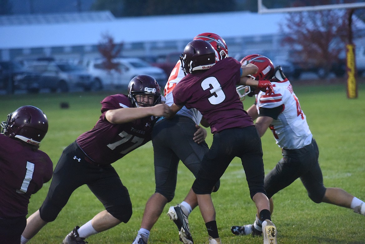 Troy freshman Carson Orr (3) and junior Derek Cole (77) team up to tackle Arlee's Jace Arca (22) on Friday, Oct. 7. (Scott Shindledecker/The Western News)