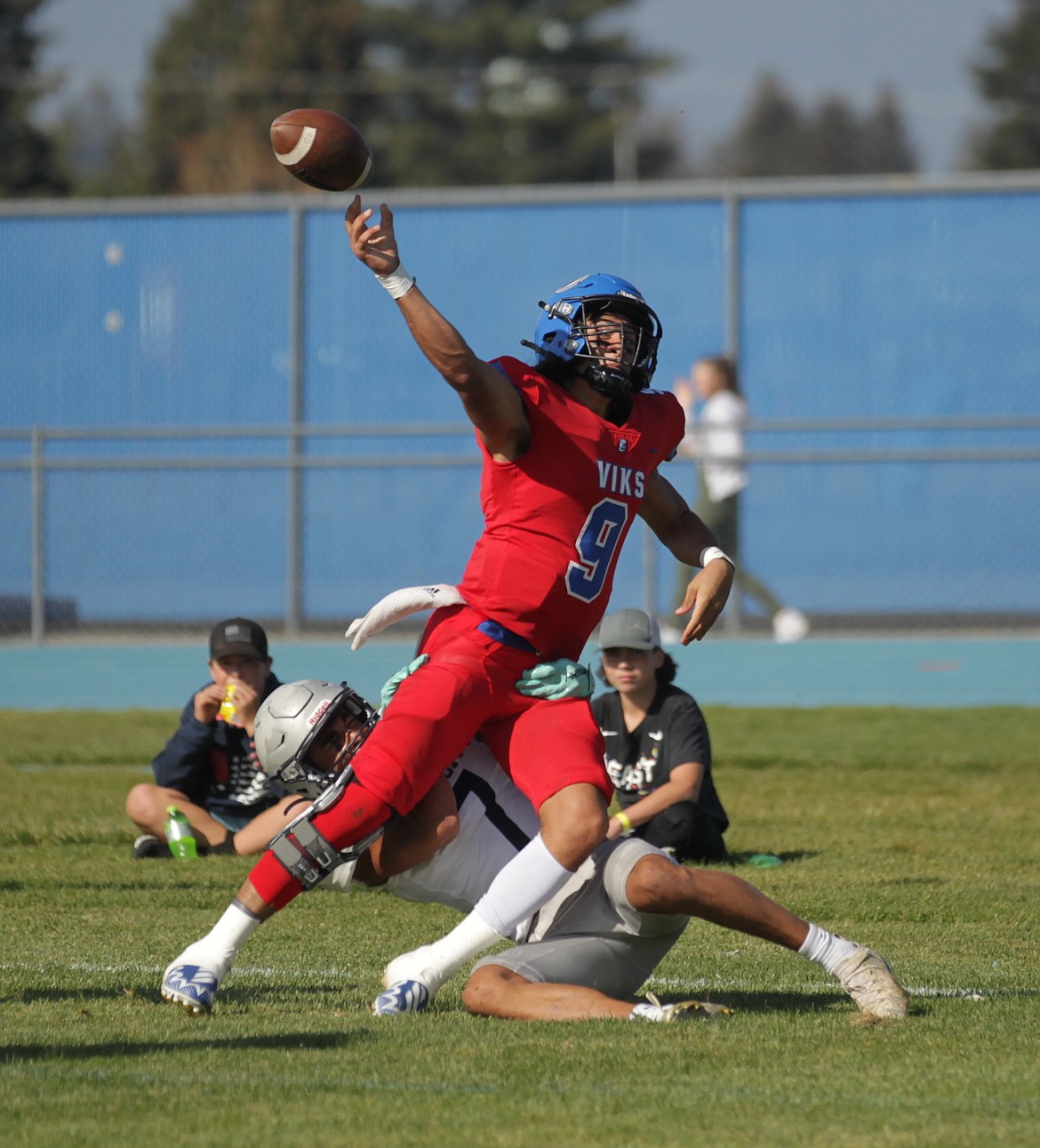 MARK NELKE/Press
Coeur d'Alene quarterback Jamison Kizziar throws a pass in the end zone while being tackled by Wayne Queen of Lake City in the first half Saturday at Coeur d'Alene High. Kizziar was called for intentional grounding, giving Lake City a safety.