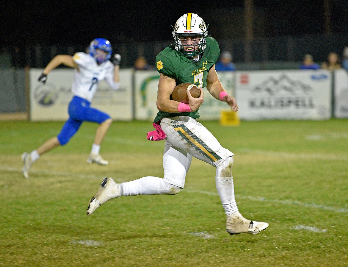 Whitefish senior Fynn Ridgeway looks behind him after breaking a tackle on a touchdown rush in the second half of a game against Libby on Friday at the Dawg Pound. (Whitney England/Whitefish Pilot)