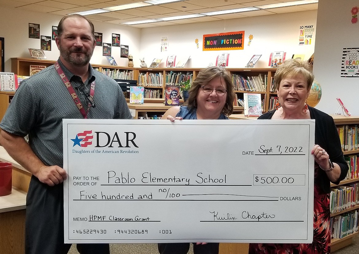 Pablo Elementary School Principal Ryan Fisher, librarian Gay Speckert and Kuilix Chapter DAR member Sharon Adamson show off check representing a $500 donation to the school library. (Photo provided)