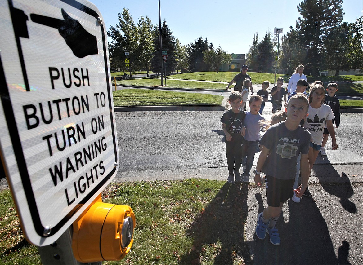 Skyway Elementary students cross at Courcelles Parkway and Hanley Avenue on Tuesday as the city introduced them to the new rectangular rapid flashing beacons.