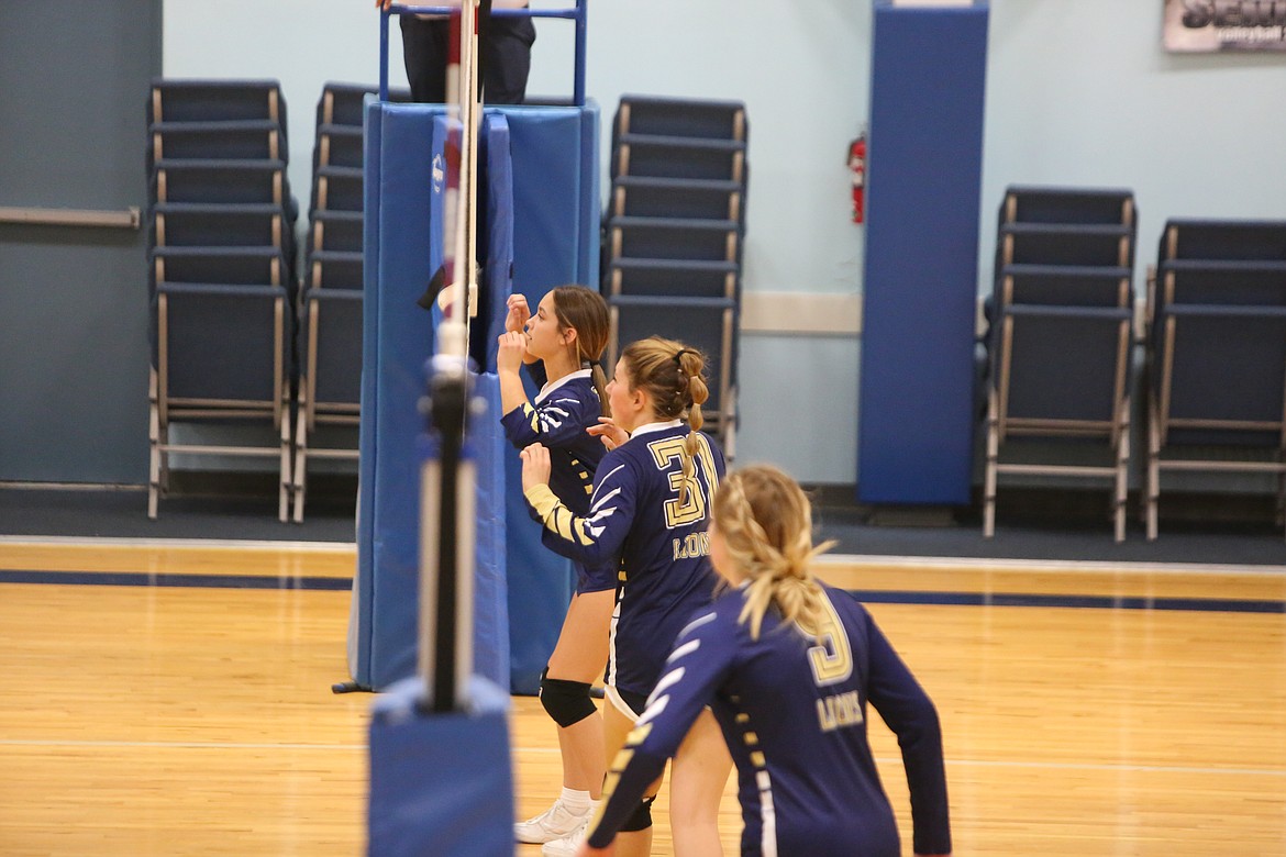 Freshman Faith Rodriguez (back center), senior Makiya Kast, middle center, and senior Kali Kast, front center, wait in the attack zone for an Entiat serve.