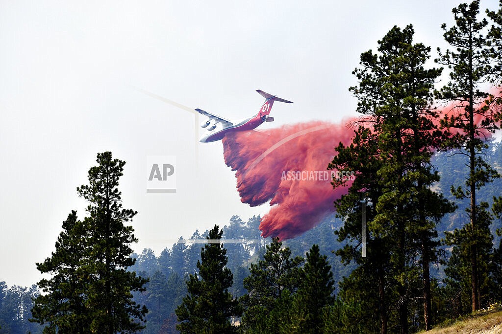 An aircraft drops fire retardant to slow the spread of the Richard Spring fire, east of Lame Deer, Mont., on Aug. 11, 2021. An environmental group alleged in a lawsuit filed Tuesday, Oct, 11, 2022, that U.S. Forest Service officials are violating pollution laws by inadvertently dropping large volumes of chemical flame retardant into streams and other waterways. (AP Photo/Matthew Brown, File)