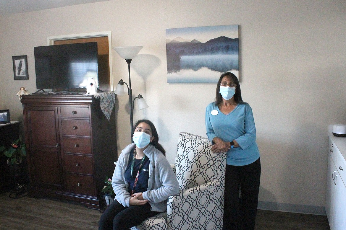 Program Director Tatiana Hernandez, left, and receptionist Janet Gonzales in a resident's room at Brookdale Hearthstone. The resident personalized her room in a number of ways, including bringing artwork from home for the walls and having vinyl flooring instead of carpet.