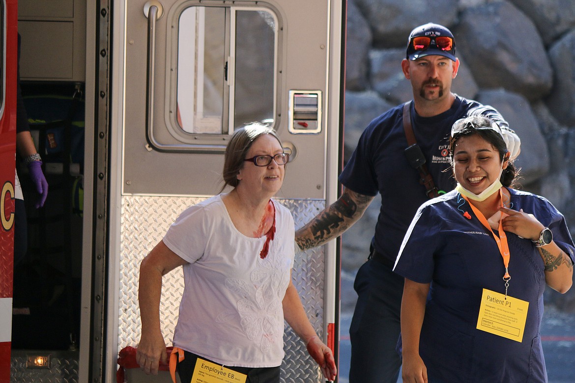 A volunteer playing the part of a shooting victim steps out of an ambulance while EMS and Confluence staff assist her during a drill on Saturday aimed at improving the response to any active shooter or mass casualty incident in Grant County.