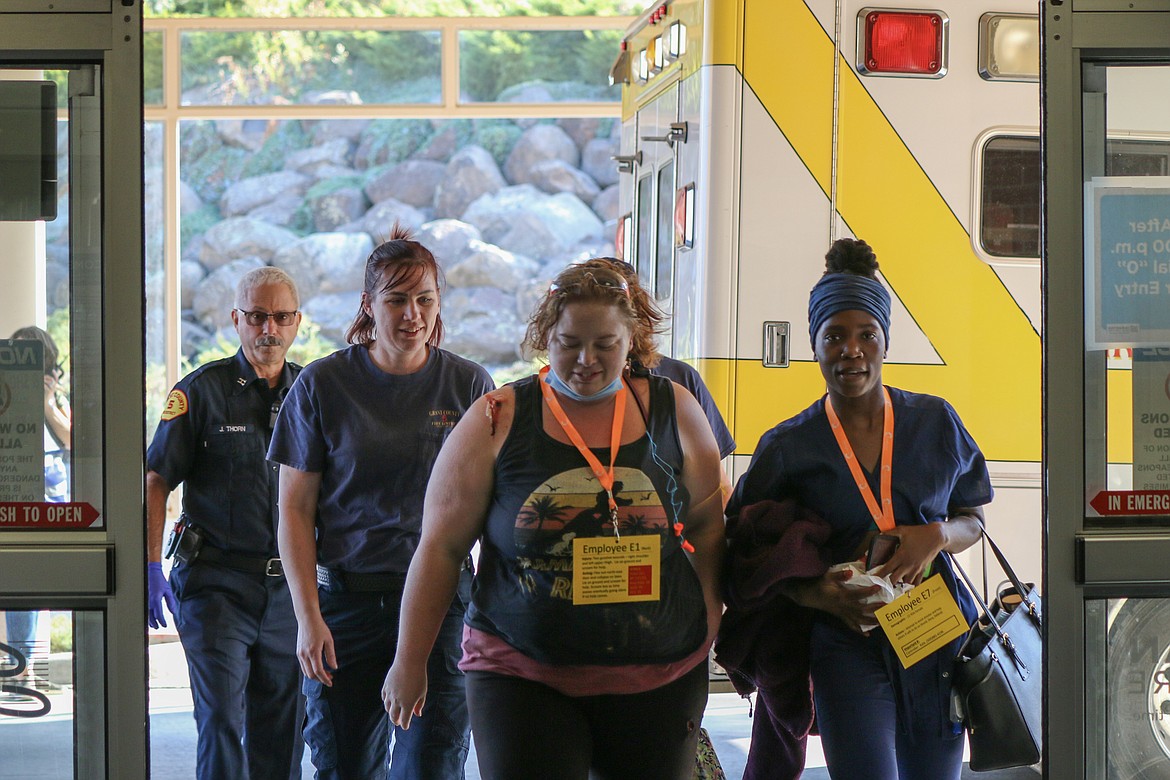 Volunteers and other exercise participants enter the Confluence clinic in Moses lake. The tags the mock victims are wearing indicate the severity of their simulated injuries for the purpose of triaging patients during the exercise.