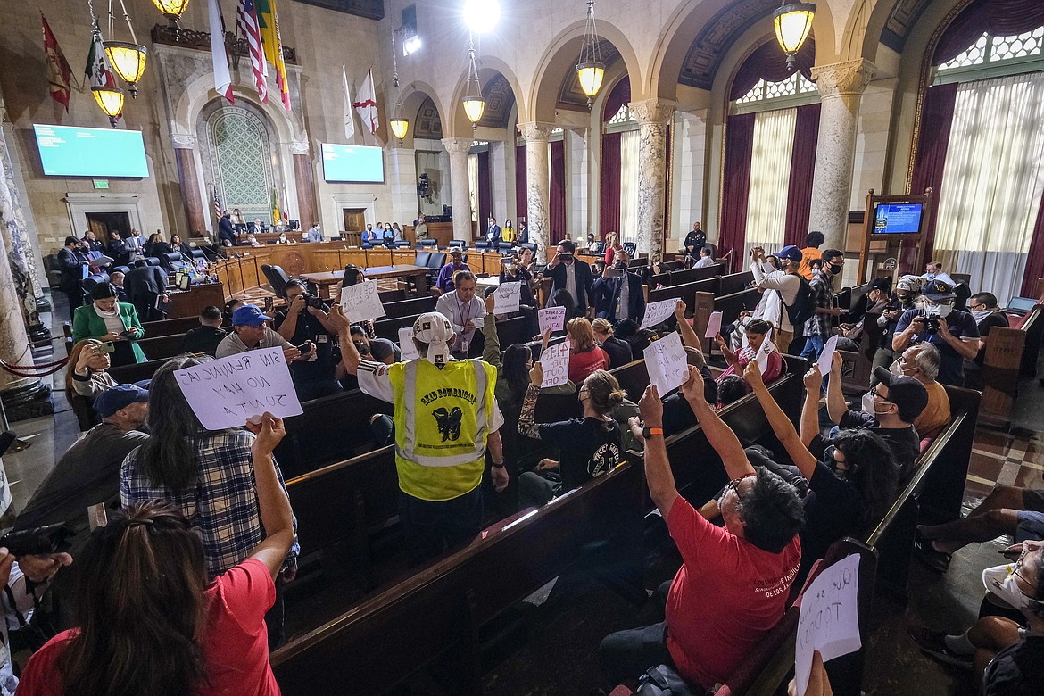 People hold signs and shout slogans as they protest before the cancellation of the Los Angeles City Council meeting Wednesday, Oct. 12, 2022, in Los Angeles. The explosive recording of Los Angeles city council members making racist and disparaging remarks have deeply hurt the city's indigenous immigrants from Mexico. (AP Photo/Ringo H.W. Chiu, File)