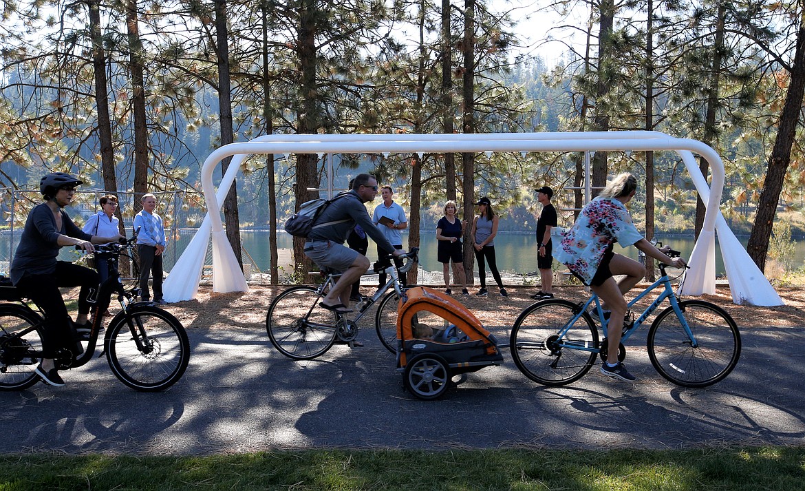 Cyclist pass by the new fitness structure near Riverstone Park on Thursday.