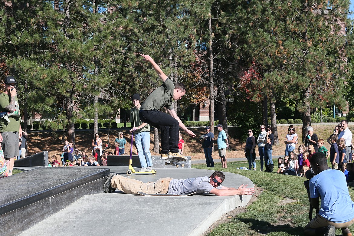 Casey Llanos wows students as he jumps his board over Sorensen dad Jake Adams at the Coeur d'Alene Skate Park on Thursday.