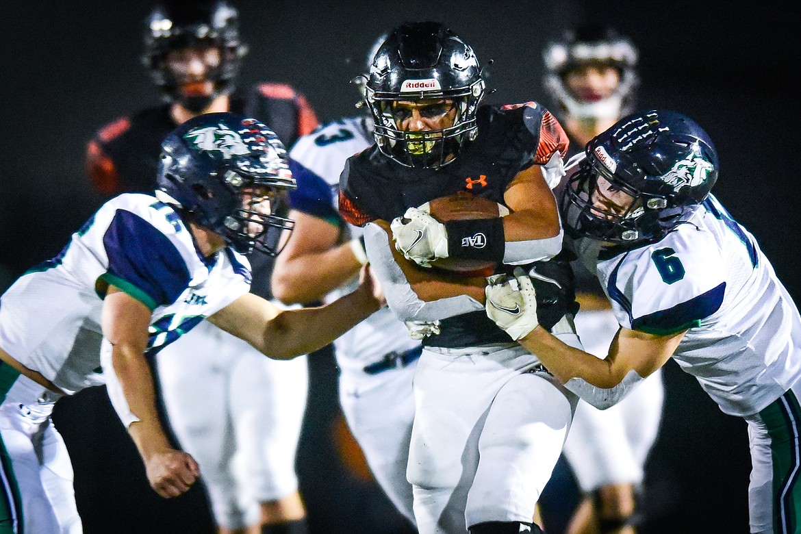 Flathead running back Joe Jones (9) is brought down by Glacier defenders Kaleb Shine (16) and Kash Goicoechea (6) on a run in the first quarter at Legends Stadium on Friday, Oct. 14. (Casey Kreider/Daily Inter Lake)