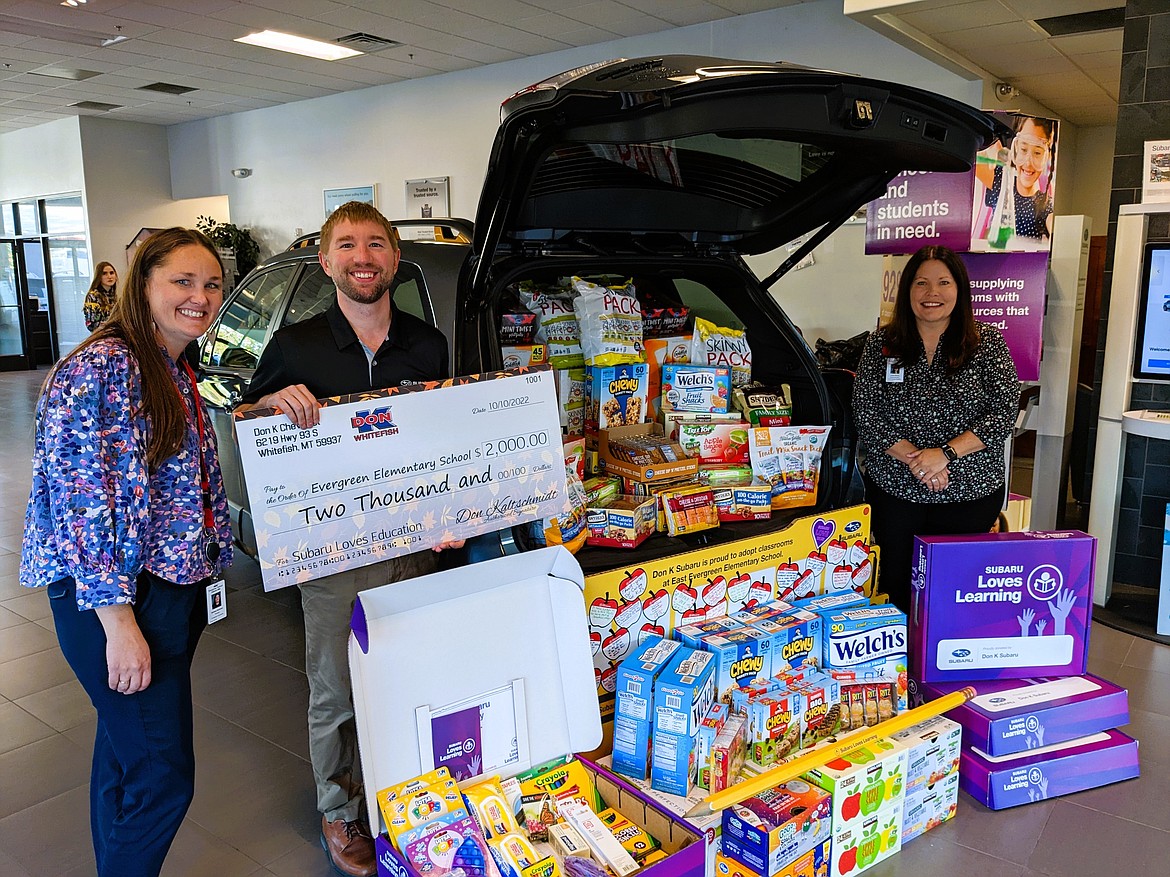 Melissa Hardman and Laurie Barron of Evergreen School District receive a Subaru Loves Learning donation from Subaru dealership general manager Kevin Kaltschmidt.