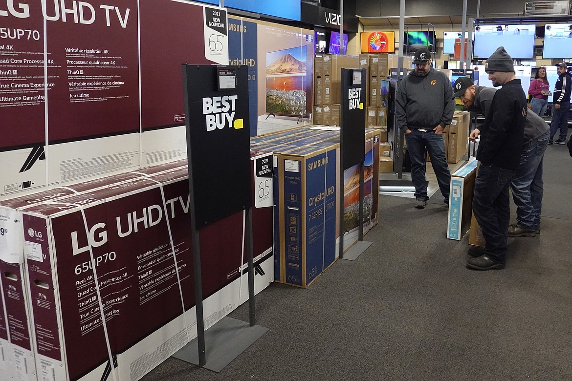 FILE - Customers debate on a television selection at Best Buy, Friday, Nov. 26, 2021, in Indianapolis. The pace of sales at U.S. retailers was unchanged in September 2022 from August as rising prices for rent and food chipped away at money available for other things. Retail sales were flat last month, down from a revised. 0.4% growth in August. (AP Photo/Darron Cummings, File)