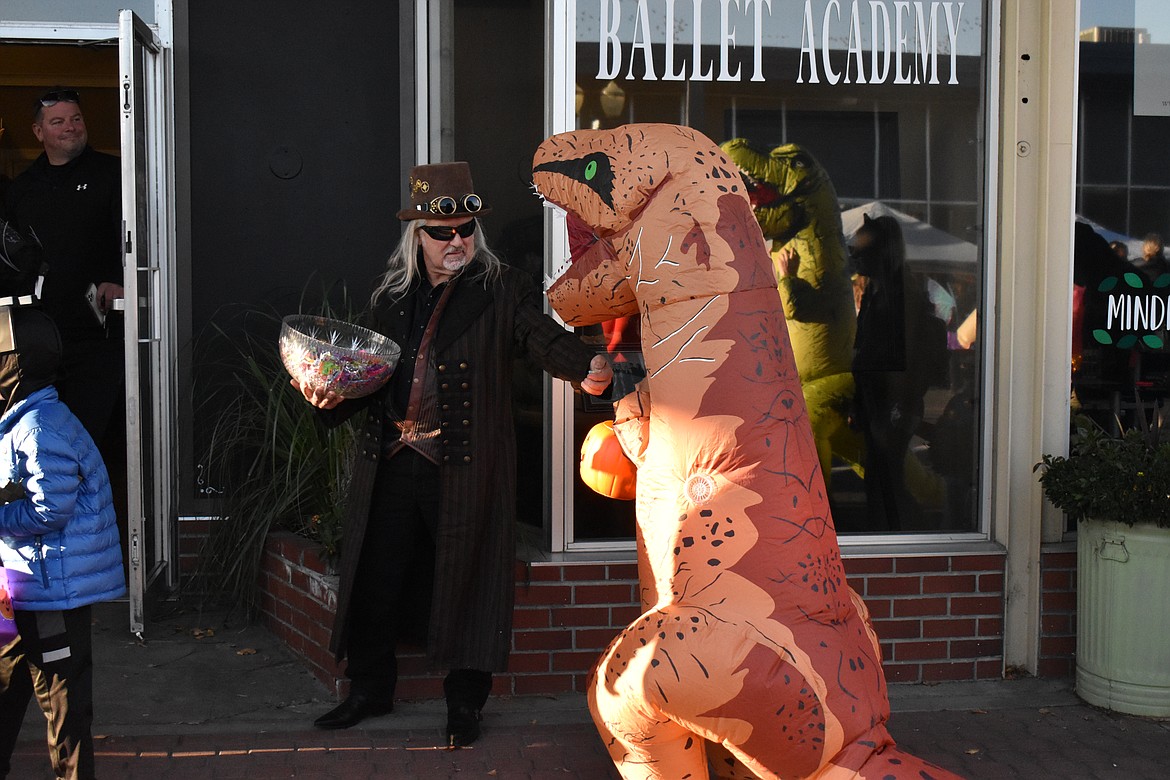 Steampunker Mike Creighton () hands candy to a trick-or-treater during the 2021 Downtown Trick or Treat Walk in Moses Lake.