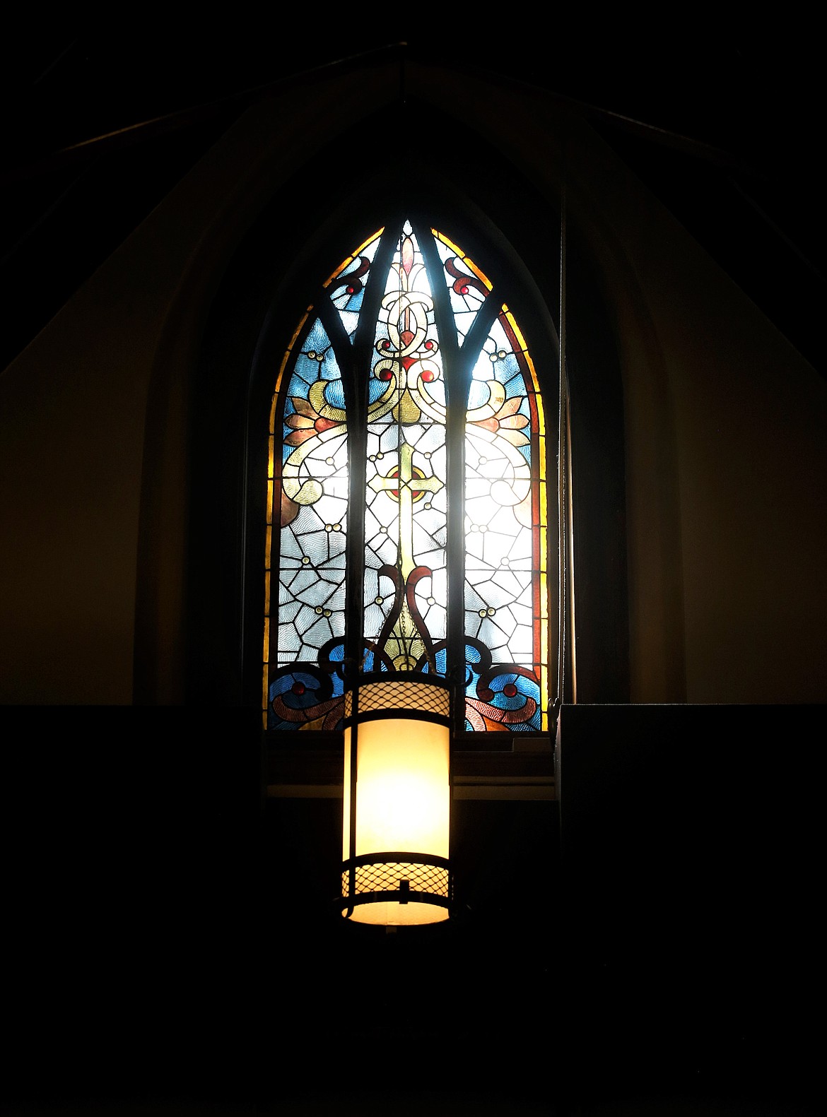Light shines in a stained-glass window at St. Luke's Episcopal Church on Friday.