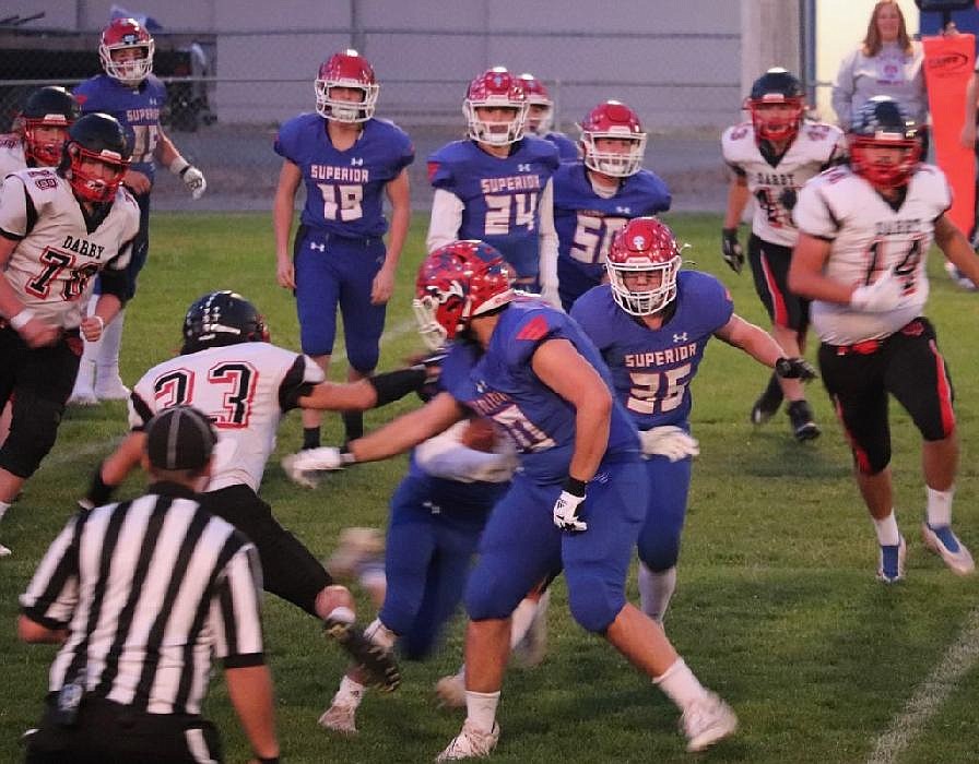 Action just after a handoff in the trenches during the game Friday night between Darby and Superior. (Photo by Kami Milender)