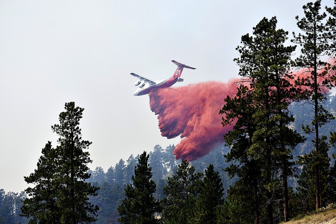 An aircraft drops fire retardant to slow the spread of the Richard Spring fire, east of Lame Deer, Mont., on Aug. 11, 2021. (AP Photo)