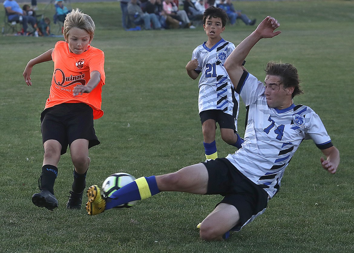 Mission Valley Christian Academy Eagle Avi Gooden slides in to block a kick by Clark Fork Soccer Alliance Clint Weedeman during a game at Plains. Tuesday’s game ended with no score and a tie. (Ed Moreth photo)