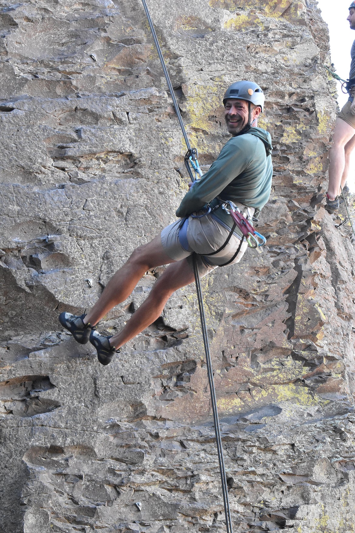 Erik Koch smiles as he belays himself down from a climb.