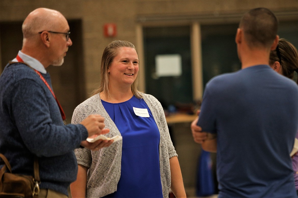 Coeur d'Alene School District trustee Heather Tenbrink, center, and Trent Derrick, assistant superintendent of secondary education, left, chat with residents during "Treats with the Trustees" at Woodland Middle School on Monday.