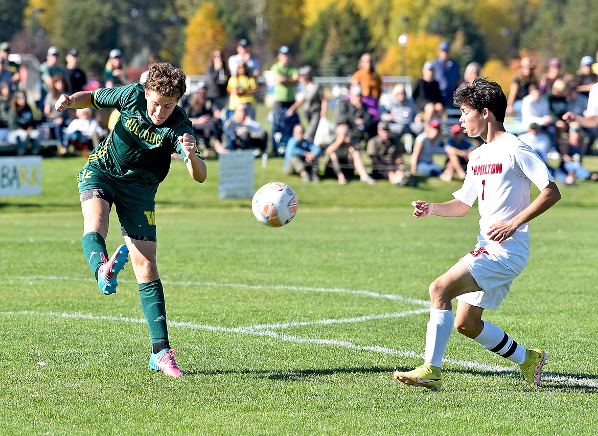 Bulldog Chris Noone boots the ball away from a Hamilton striker during a Class A quarterfinal playoff game on Saturday at Smith Fields. (Whitney England/Whitefish Pilot)
