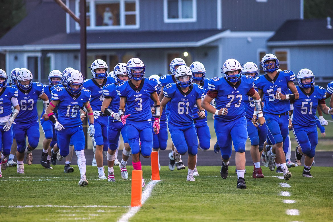 The Wildcats charge the field for their rivalry game against Whitefish on Friday. (JP Edge photo)