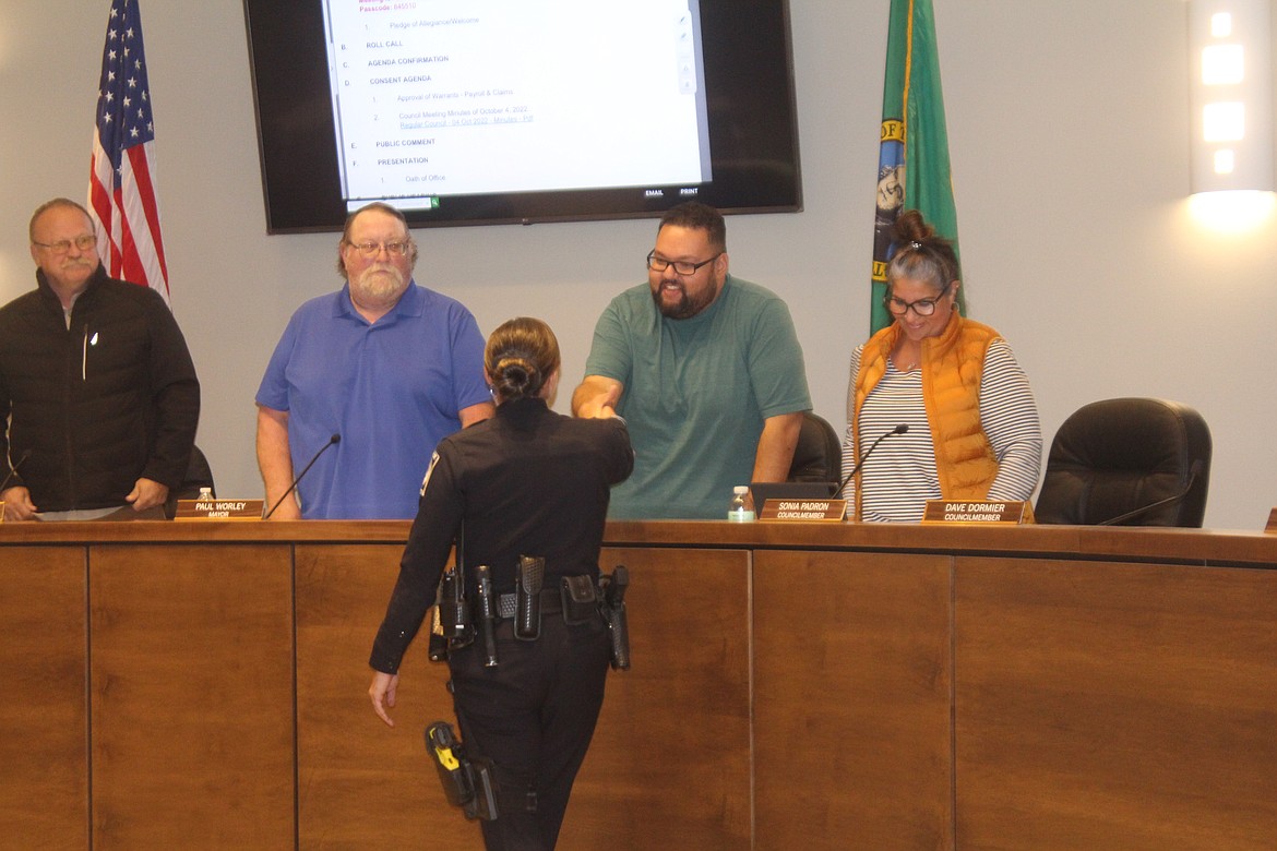 New Quincy Police Department officer Emily Pratt, front, shakes hands with Quincy City Council member Dylan Klin. 
From left: Council Member Tom Harris, Mayor Paul Worley and Council Member Sonia Padron look on.