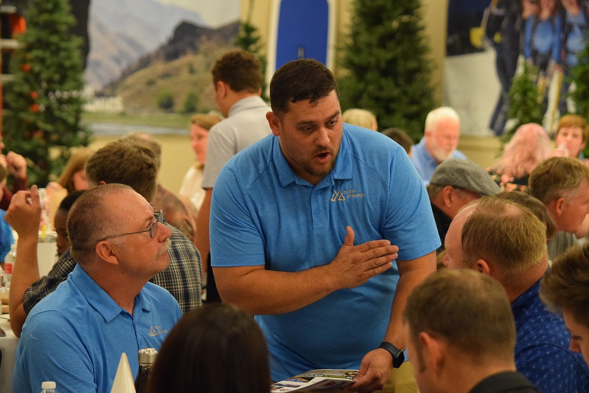 Youth Dynamic Moses Lake Director Sean Sallis (standing) talks with auctioneer Chuck Yarbro prior to the auction portion of the group’s annual fundraiser banquet and auction, which took in more than $40,000.