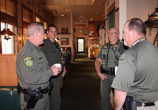 From left, Kootenai County Sheriff Robert Norris, Lt. Mark Ellis, Capt. Stuart Miller and Lt. Ryan Higgins talk over coffee Thursday in Rustler's Roost while waiting for attendees to arrive for the Morning Coffee Meetup. The officers answered questions on a range of topics from the community.