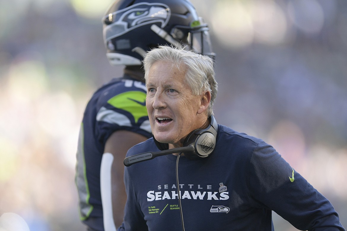 Seattle Seahawks head coach Pete Carroll greets players during the second half of his team's NFL football game against the Arizona Cardinals in Seattle, Sunday, Oct. 16, 2022.