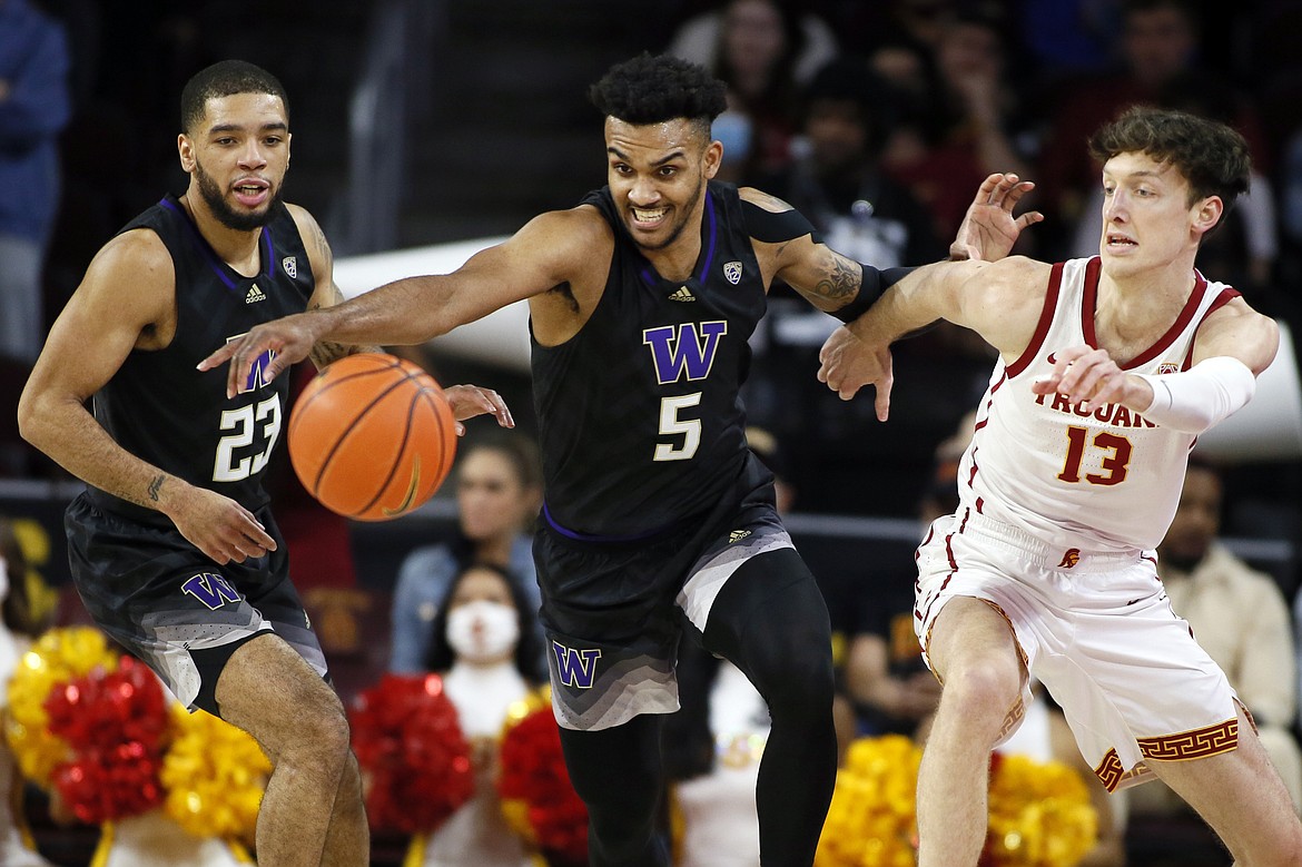 FILE - Washington guard Jamal Bey, center, attempts to steal the ball from Southern California guard Drew Peterson, right, with Washington guard Terrell Brown Jr. watching during the first half of an NCAA college basketball game in Los Angeles, Thursday, Feb. 17, 2022. Bey is Washington’s returning scorer leader after averaging 9.4 points per game last season. He’s also Washington’s most experienced player beginning the season with 119 career games played.