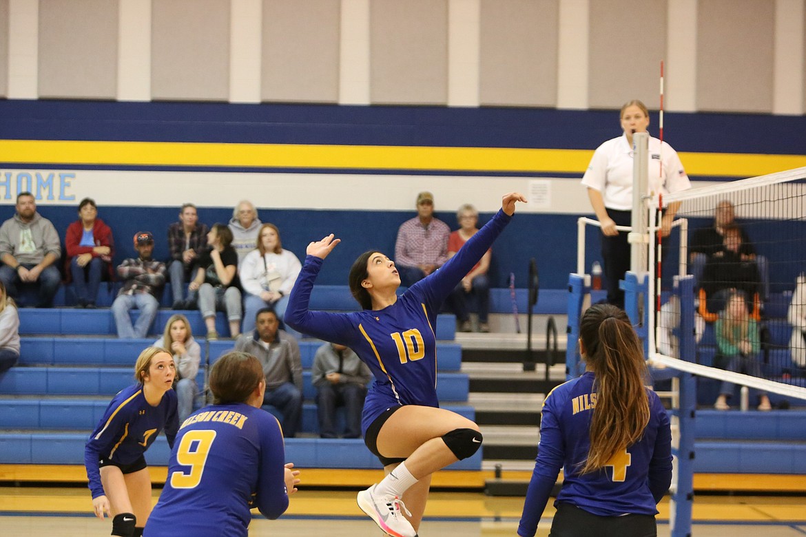 Jumping in the air, junior Rocio Marin Villegas tracks the ball prior to a volley over the net.