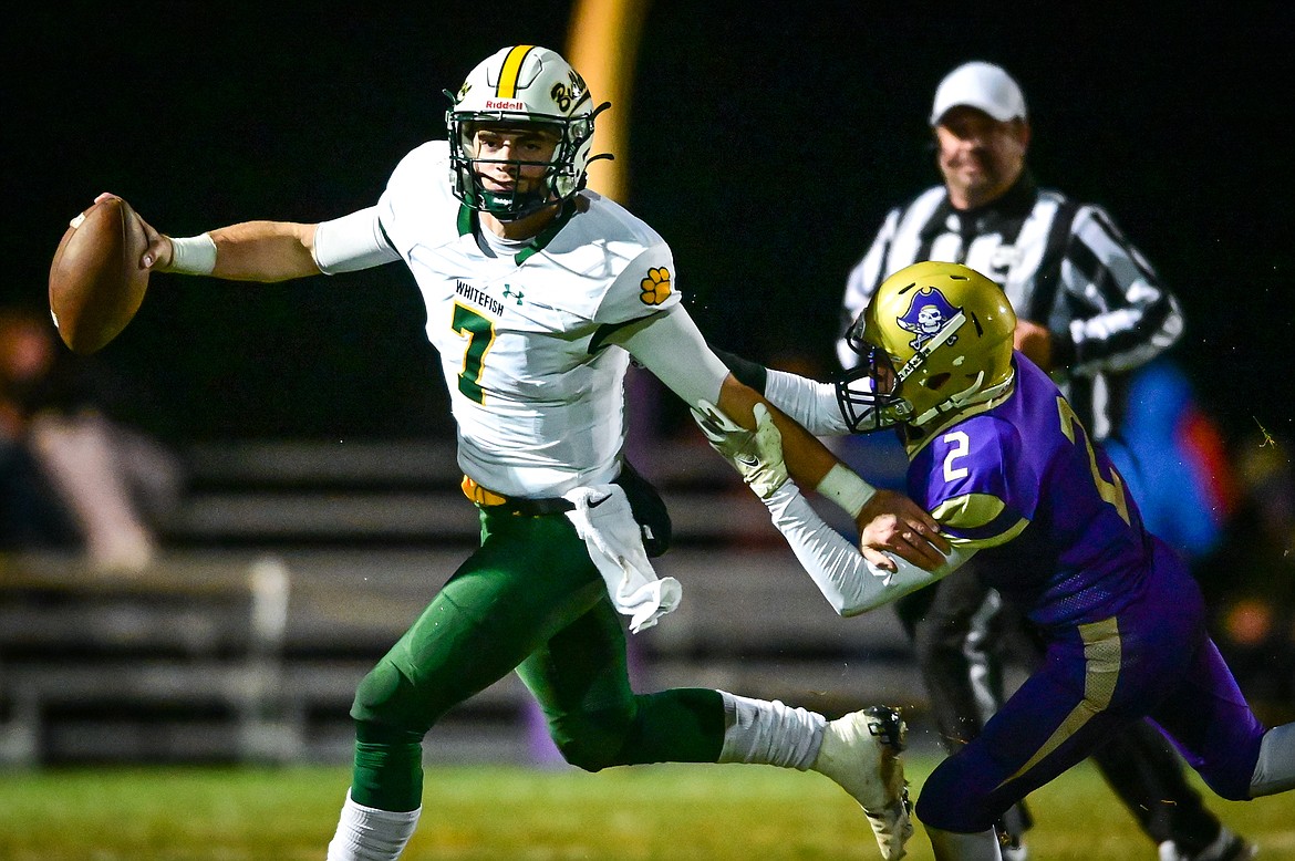 Whitefish quarterback Fynn Ridgeway (7) rolls out looking to pass under pressure from Polson's Colter Wilson (2) in the first quarter against Polson at Polson High School on Friday, Oct. 21. (Casey Kreider/Daily Inter Lake)