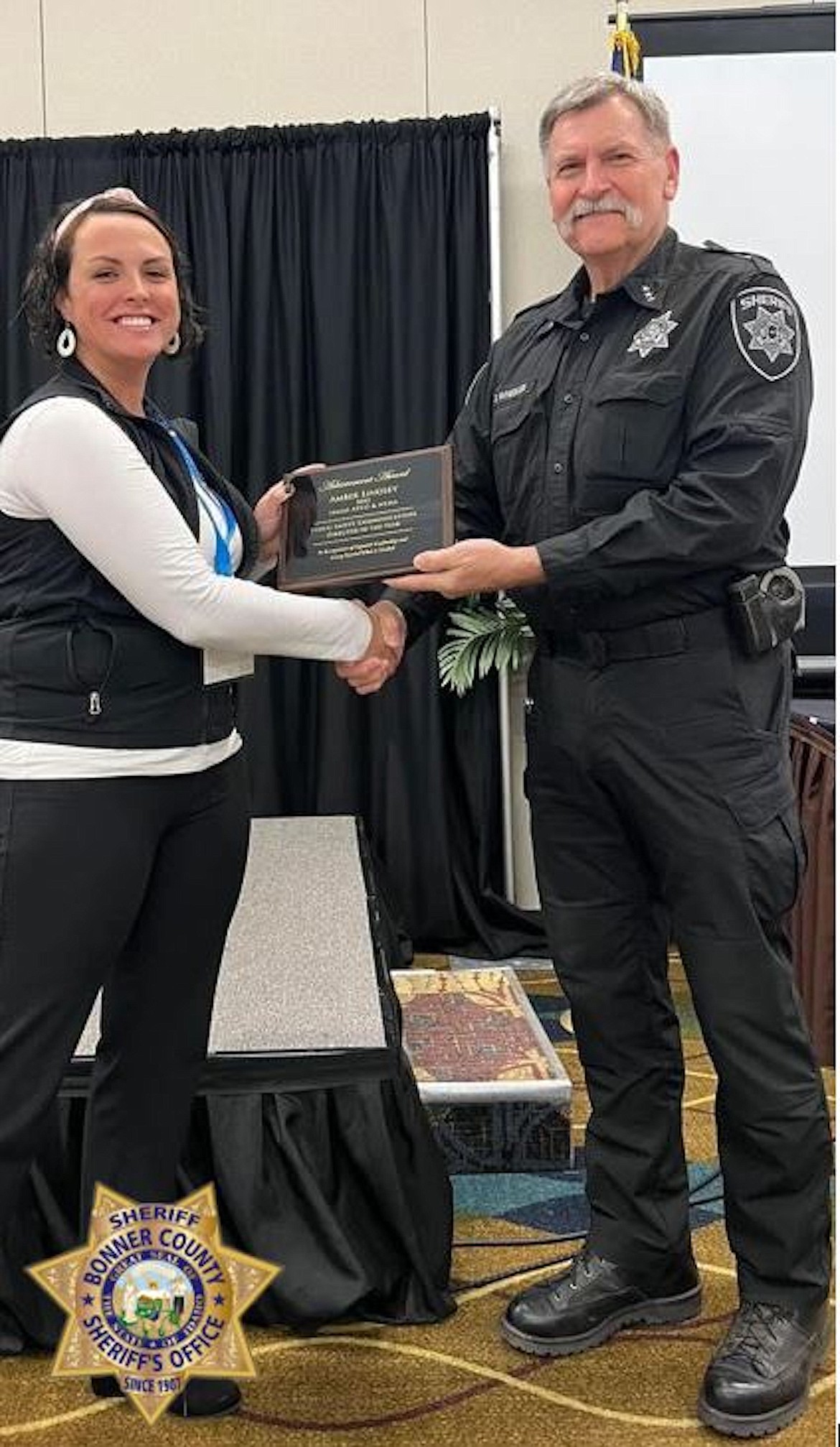 Sheriff Daryl Wheeler congratulates Amber Lindsey on receiving the Idaho Association of Public Safety Communications Officials' yearly award for "Public Safety Communications Director of the Year."