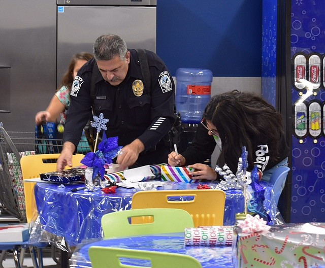 Quincy Police officers and staff wrap packages for children and their families during a previous Cops & Kids distribution. The department is sponsoring a fundraising raffle and taking donations for Cops & Kids 2022.