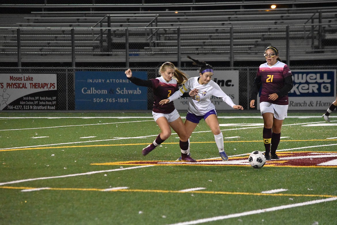 Freshman Reese Prescott (2) and senior Abril Rodriquez (21) come in to guard on both sides of a Wenatchee player during the conference matchup on Tuesday evening.