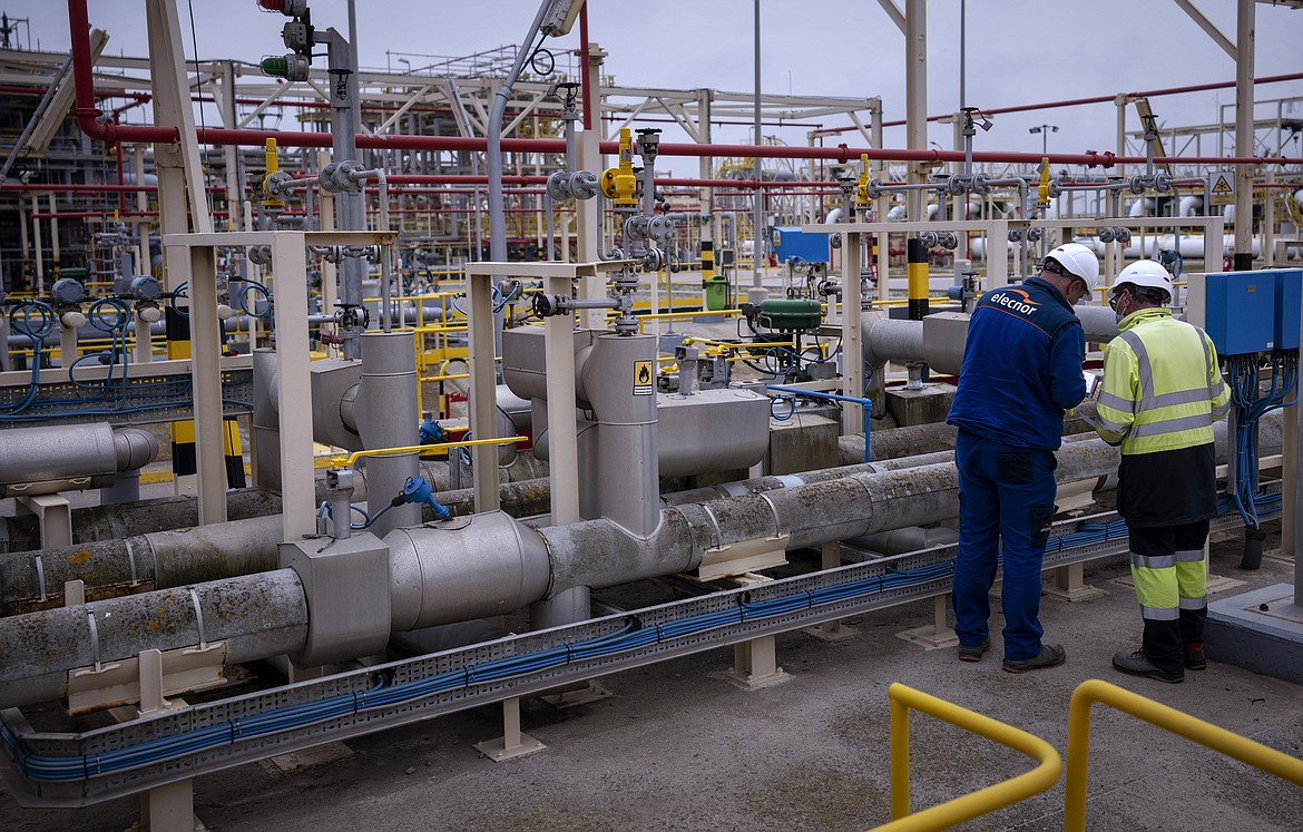 Operators work at Enagas regasification plant, the largest LNG plant in Europe, in Barcelona, Spain, March 29, 2022. Natural gas and electricity prices in Europe have plunged from summer peaks thanks to mild weather and a monthslong scramble to fill gas storage ahead of winter and replace Russian supplies during the war in Ukraine. It's a welcome respite after Russia slashed natural gas flows, triggering an energy crisis that has fueled record inflation and a looming recession. (AP Photo/Emilio Morenatti, File)