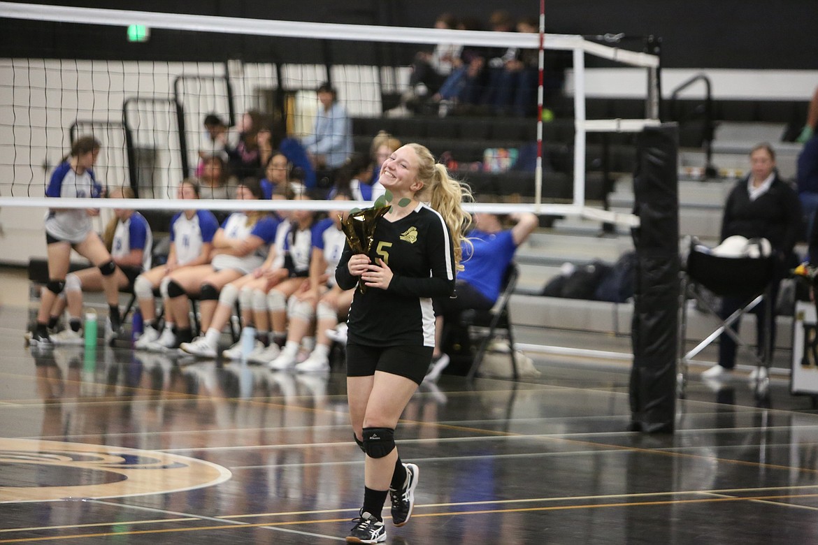 Royal volleyball senior Jocelyn Jenks walks across the court with flowers in hand during the senior night ceremonies on Oct. 25.