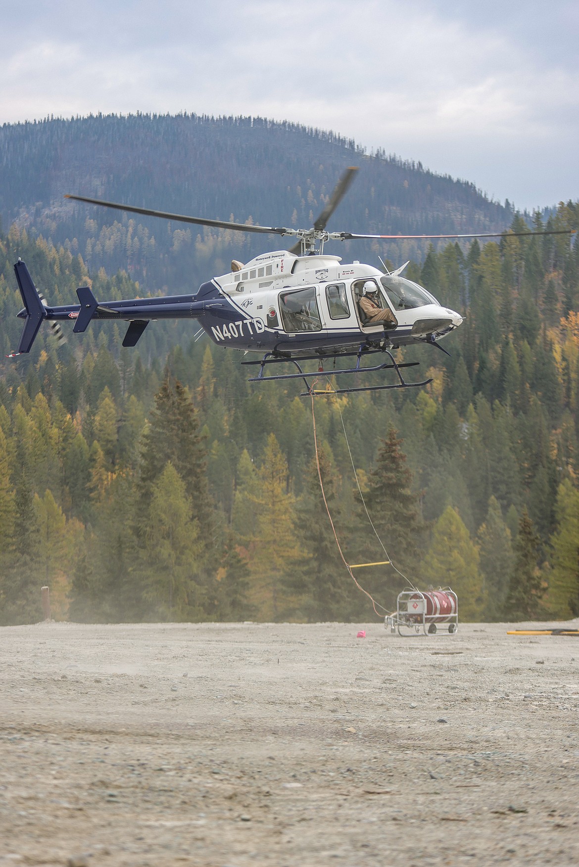 A Forest Service helicopter loaded with a Flash 21 canister takes off for a prescribed burn on Big Mountain on Oct. 20. (JP Edge photo)