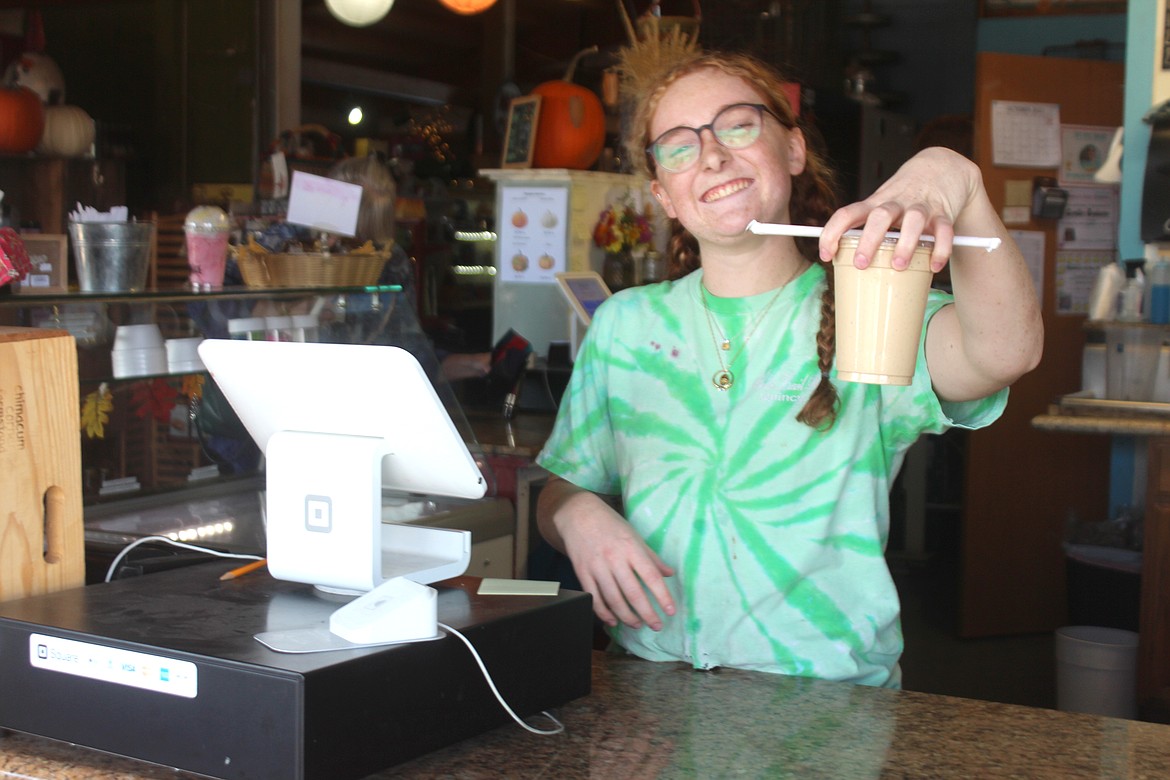 Employee Paige Wood shows off one of the famous milkshakes from White Trail Produce near Quincy.